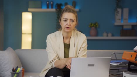 Home-office-worker-woman-looking-at-camera-depressed.